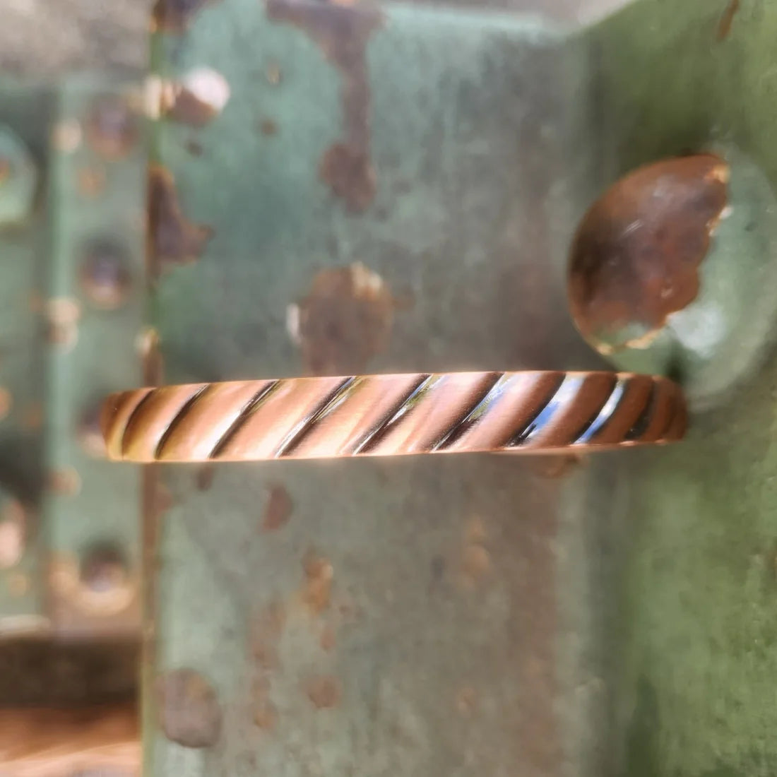 Close-up horizontal view of spiral rope texture on copper cuff bracelet