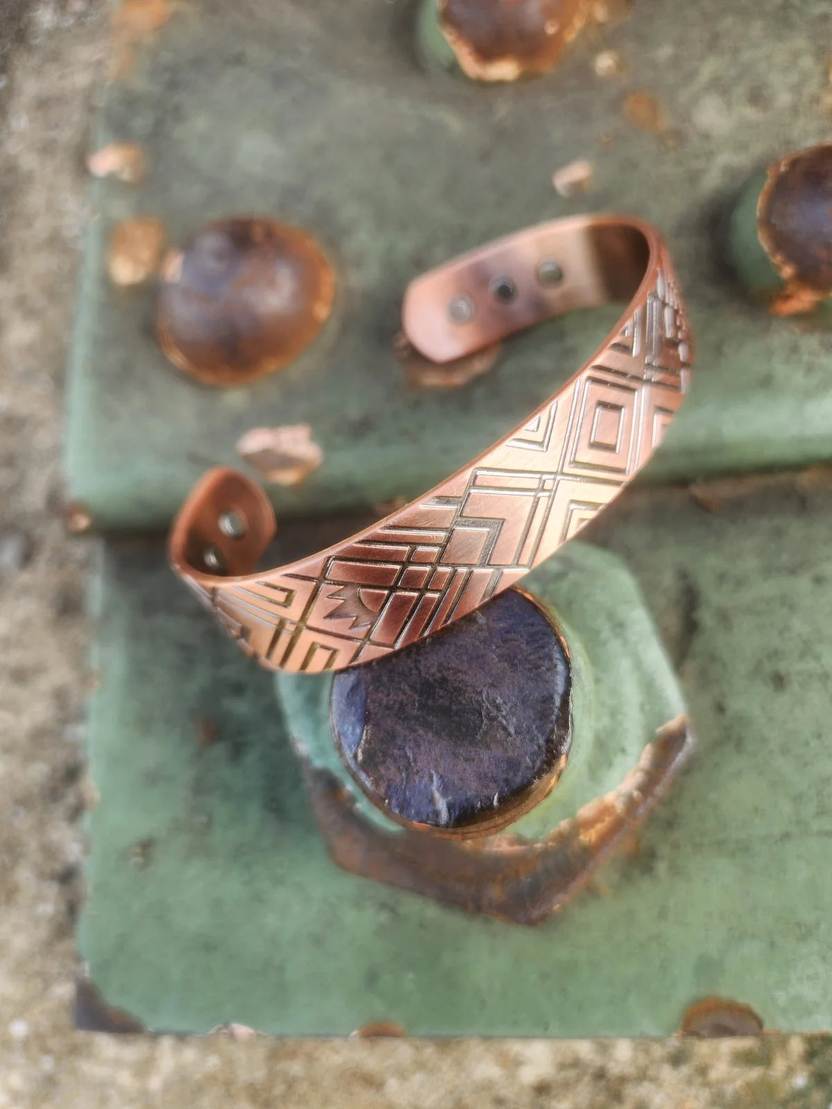 Angled view of diamond and cross geometric magnetic copper cuff showing inset magnets