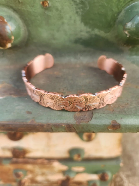 Front view of floral copper cuff with layered petal pattern