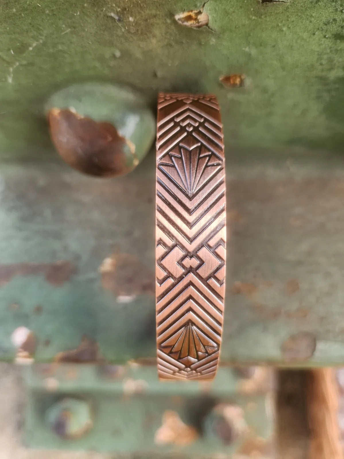 Detailed view of chevron and geometric fan motif on copper cuff