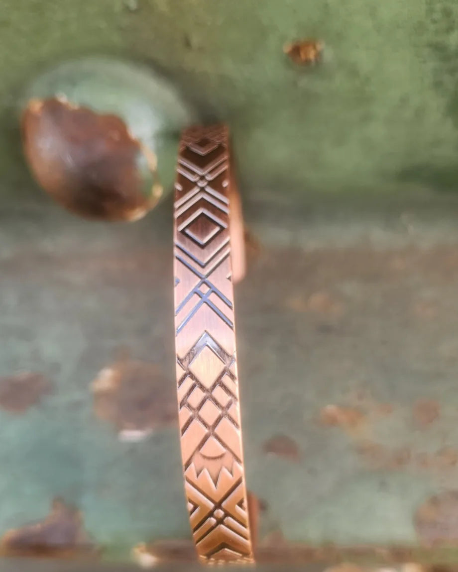 Side detail of thin geometric magnetic copper cuff