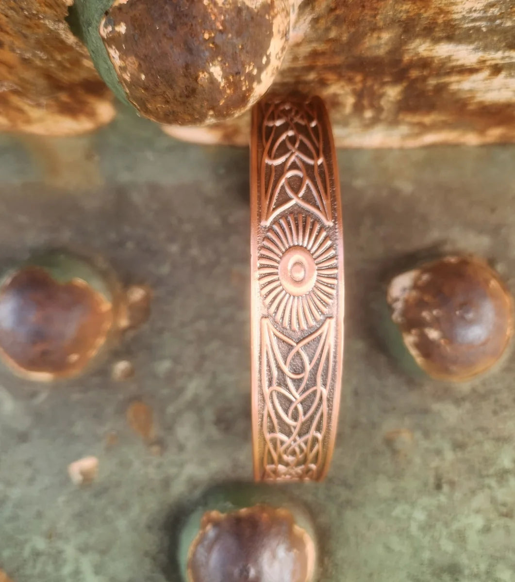 Close-up of the sunburst design on copper cuff